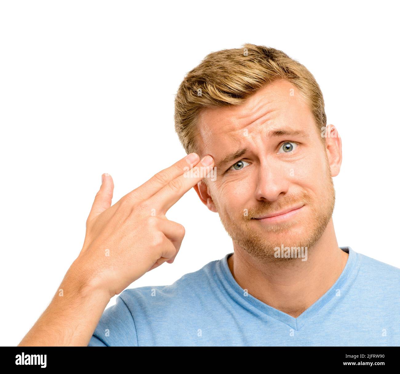 Im so over this. Shot of a handsome young man standing alone in the studio and holding his fingers to his head. Stock Photo