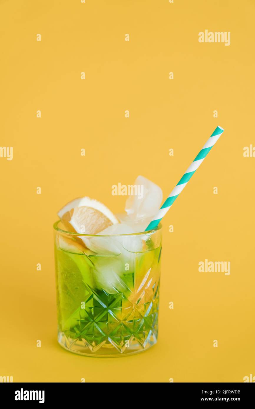 sliced citrus fruit in glass with mojito drink and straw on yellow Stock Photo