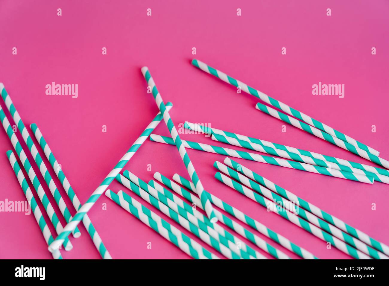 top view of striped blue and white straws on pink background Stock Photo