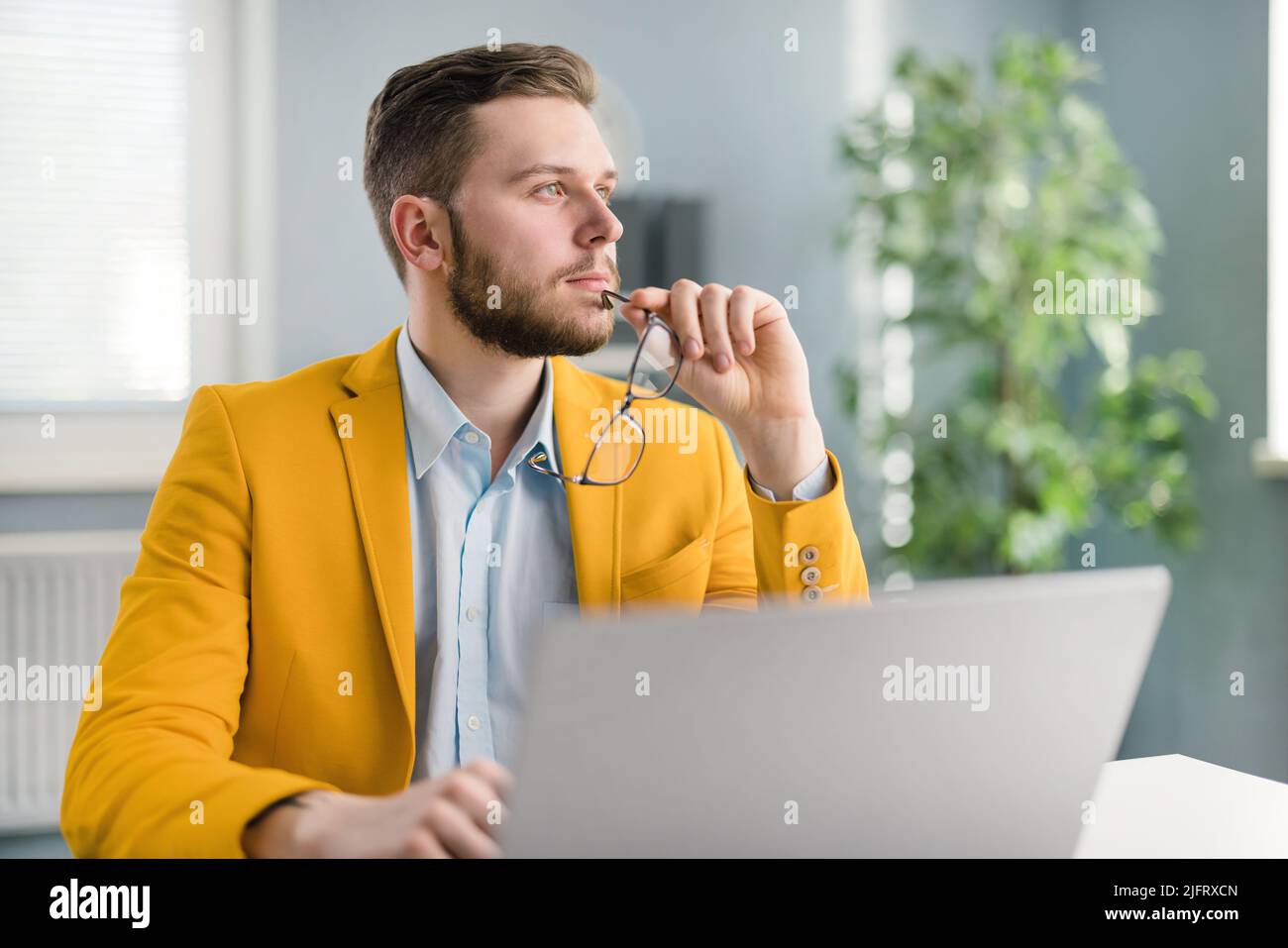 Pensive office worker with laptop Stock Photo