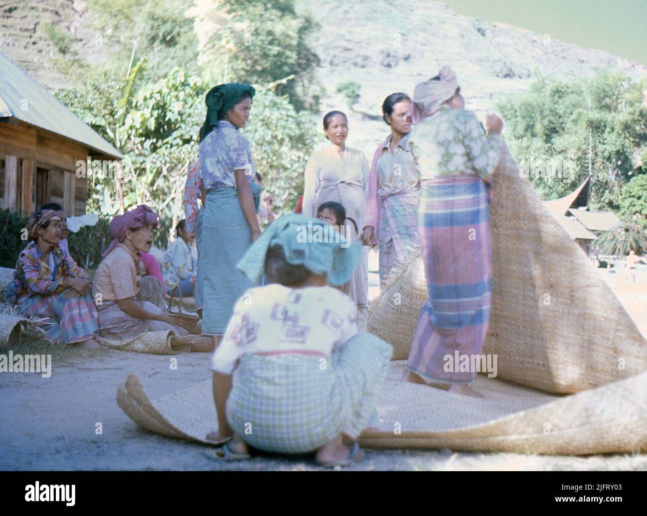 Sumatra, circa.1970. A group of local Batak women selling hand-woven mats at a rural market near Lake Toba. Stock Photo