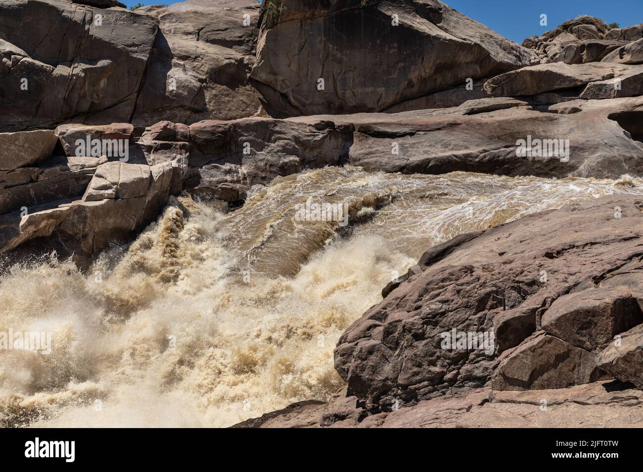 Rushing flood water at the Augrabies National Park in South Africa.  The water is the Orange river. Granite rock formations can be seen. Stock Photo