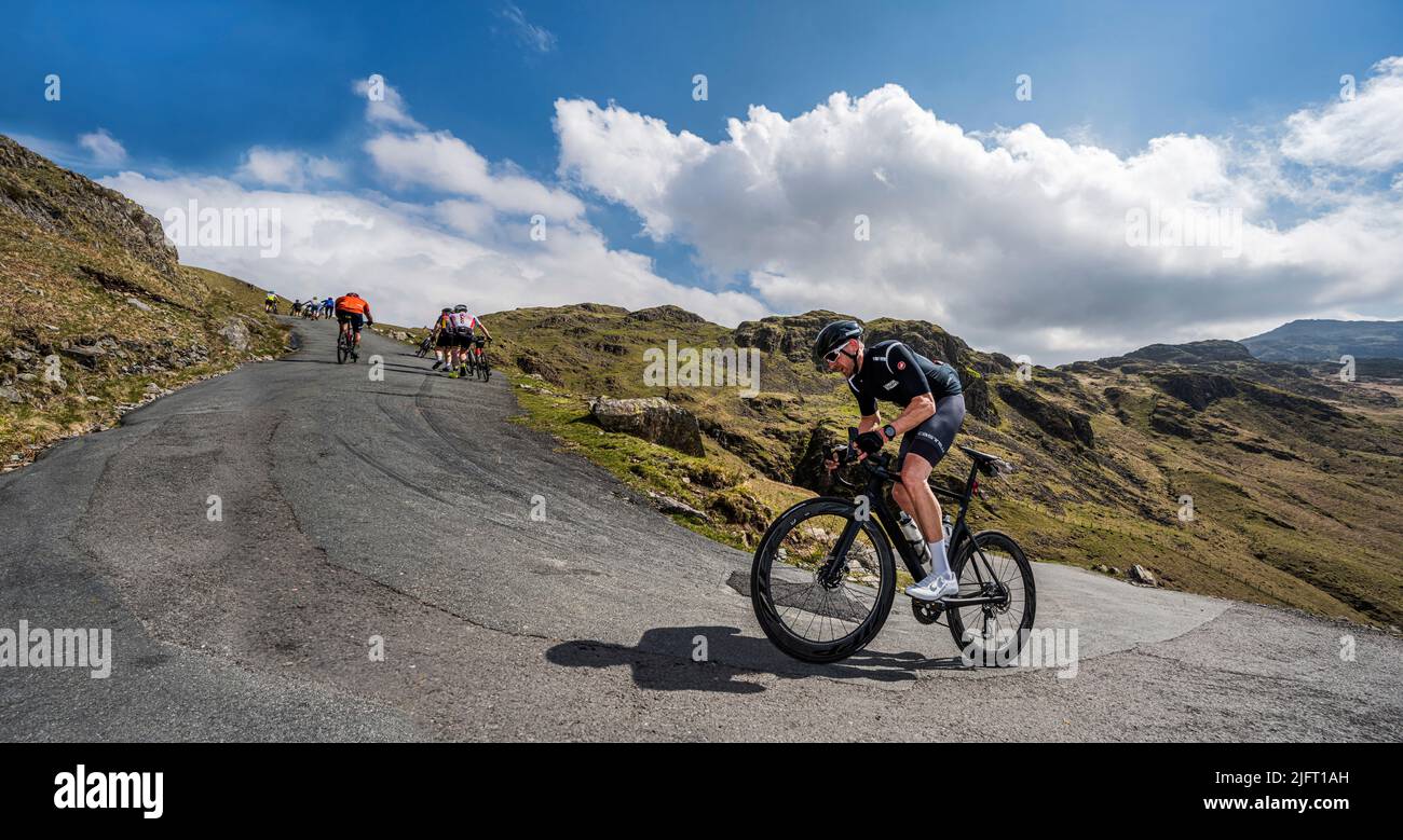 A male road cyclist rounding the hairpin bend on Hardknott Pass, Fred Whitton Challenge, English Lake District. Stock Photo