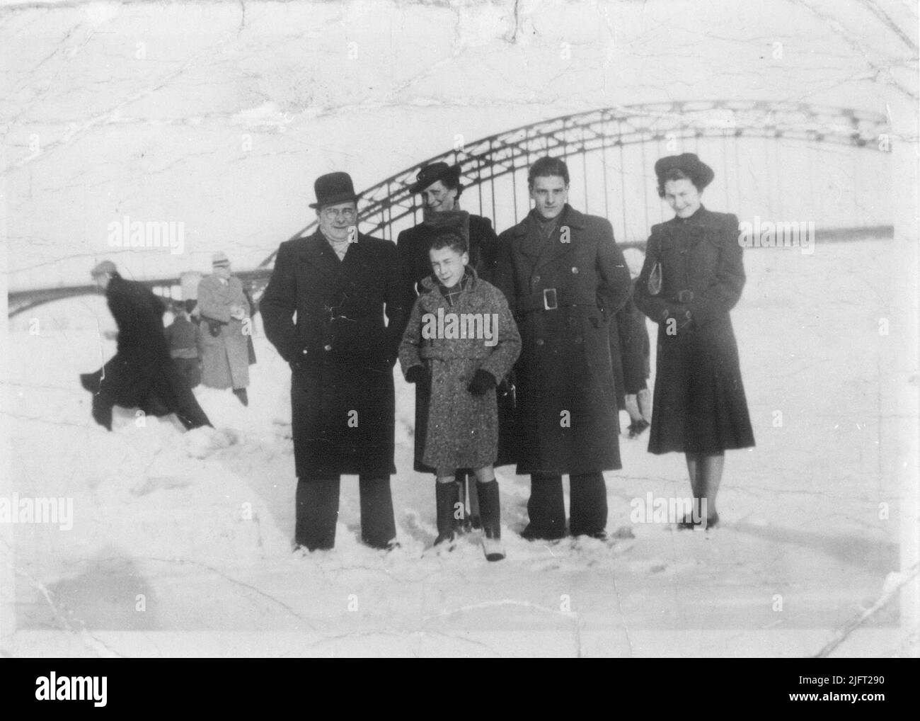 Severe winters, and a frozen river Waal; The Van Haaren family from the Grotestraat standing on the ice on the river Waal, in the background the Waalbrug Stock Photo