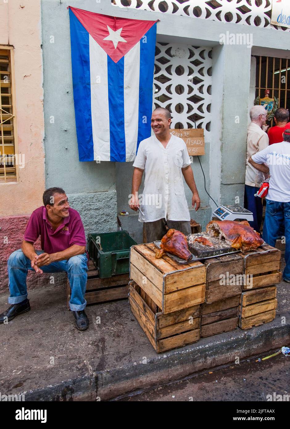 Cuba, Santiago de Cuba. Man selling pork at streetmarket Stock Photo