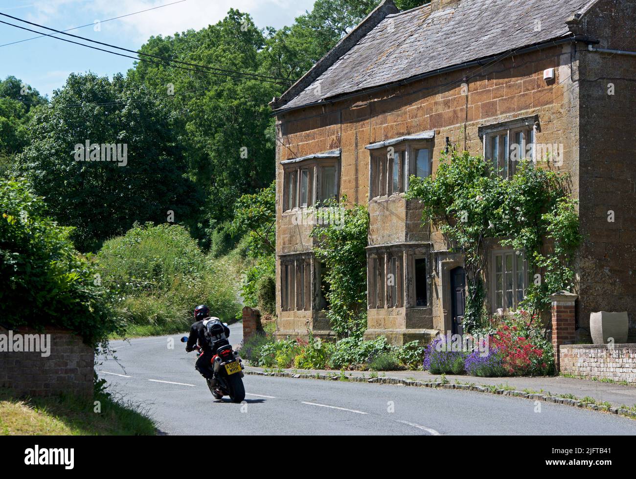Man riding motorbike in the village of Weston by Welland, Northamptonshire, England UK Stock Photo