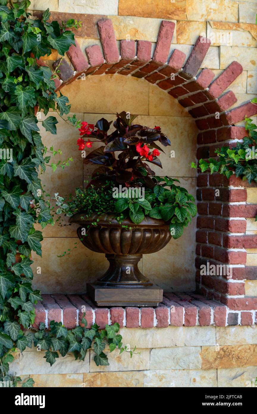 Antique vase with flowers inside brick arch. Background picture. Park Gorkogo - Ukraine, Odessa. Stock Photo