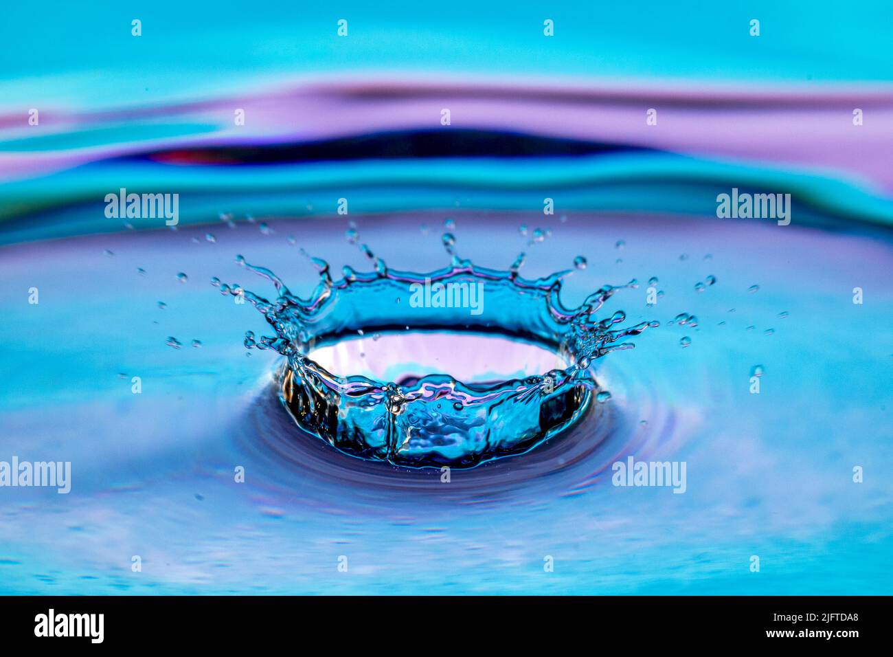 Water splash isolated on colorful background. Stock Photo