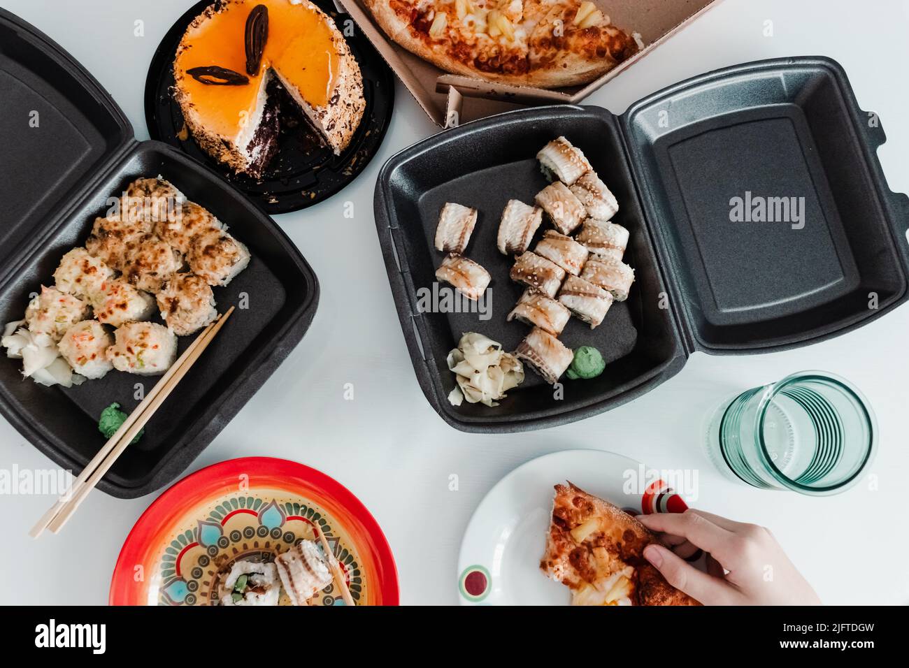 Party table with take out food in plastic package. Pizza, sushi rolls and cake photo for menu. Food delivery Stock Photo