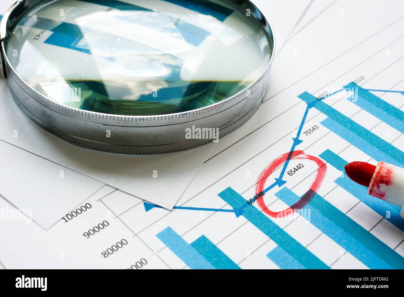 Magnifying glass and financial report. Internal Controls and audit concept. Stock Photo