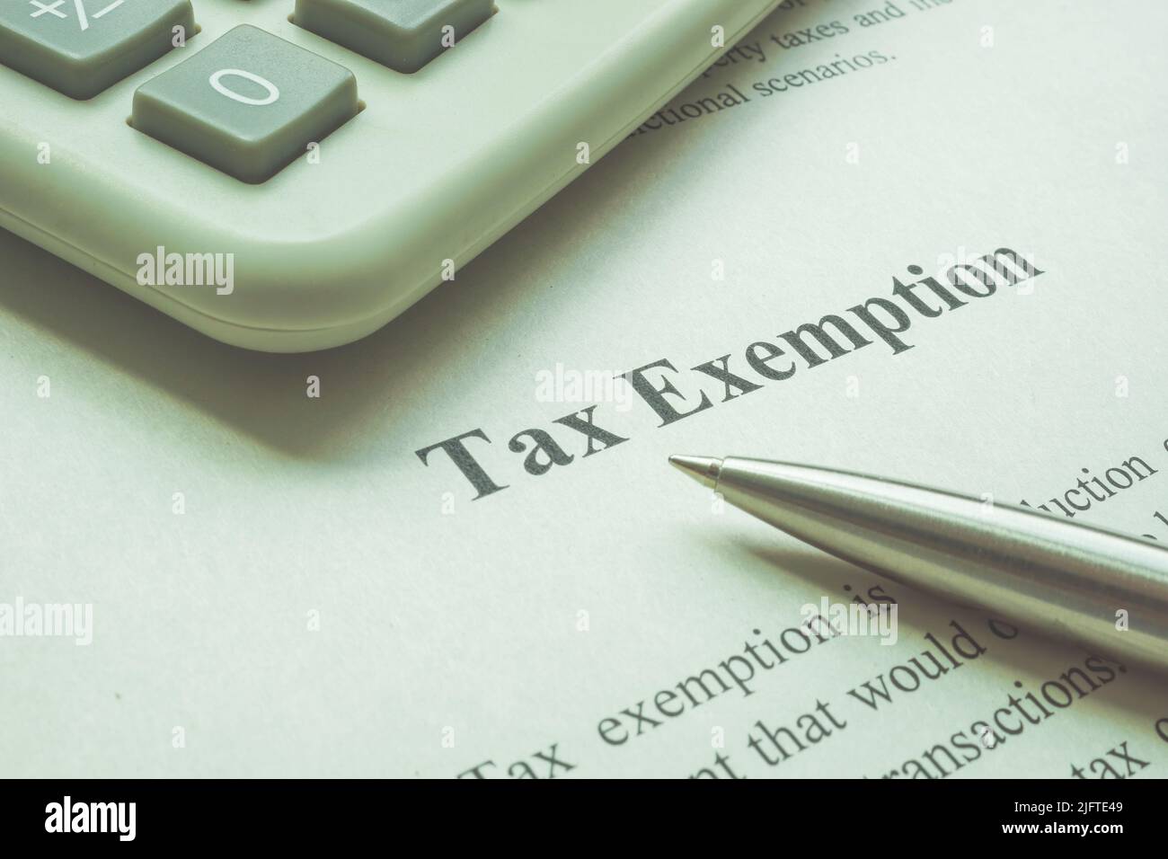 Info about tax exemption with calculator and pen. Stock Photo