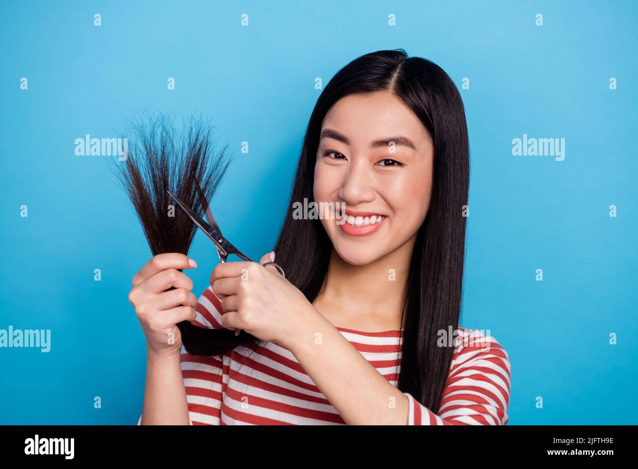 Portrait of positive malaysian person hold scissors cut hair toothy ...
