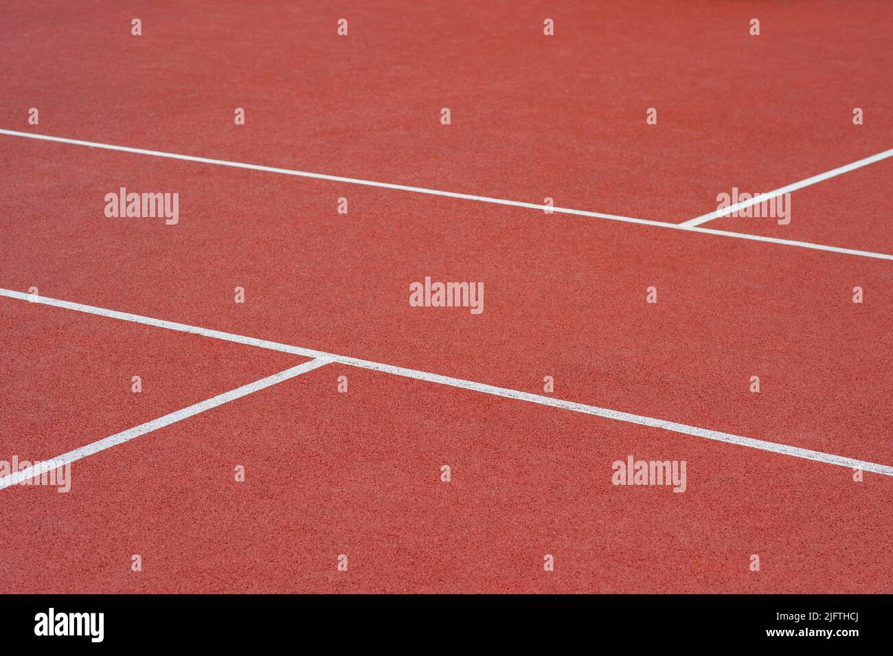 Close up on a white line in artificial red turf, on a street basketball ...