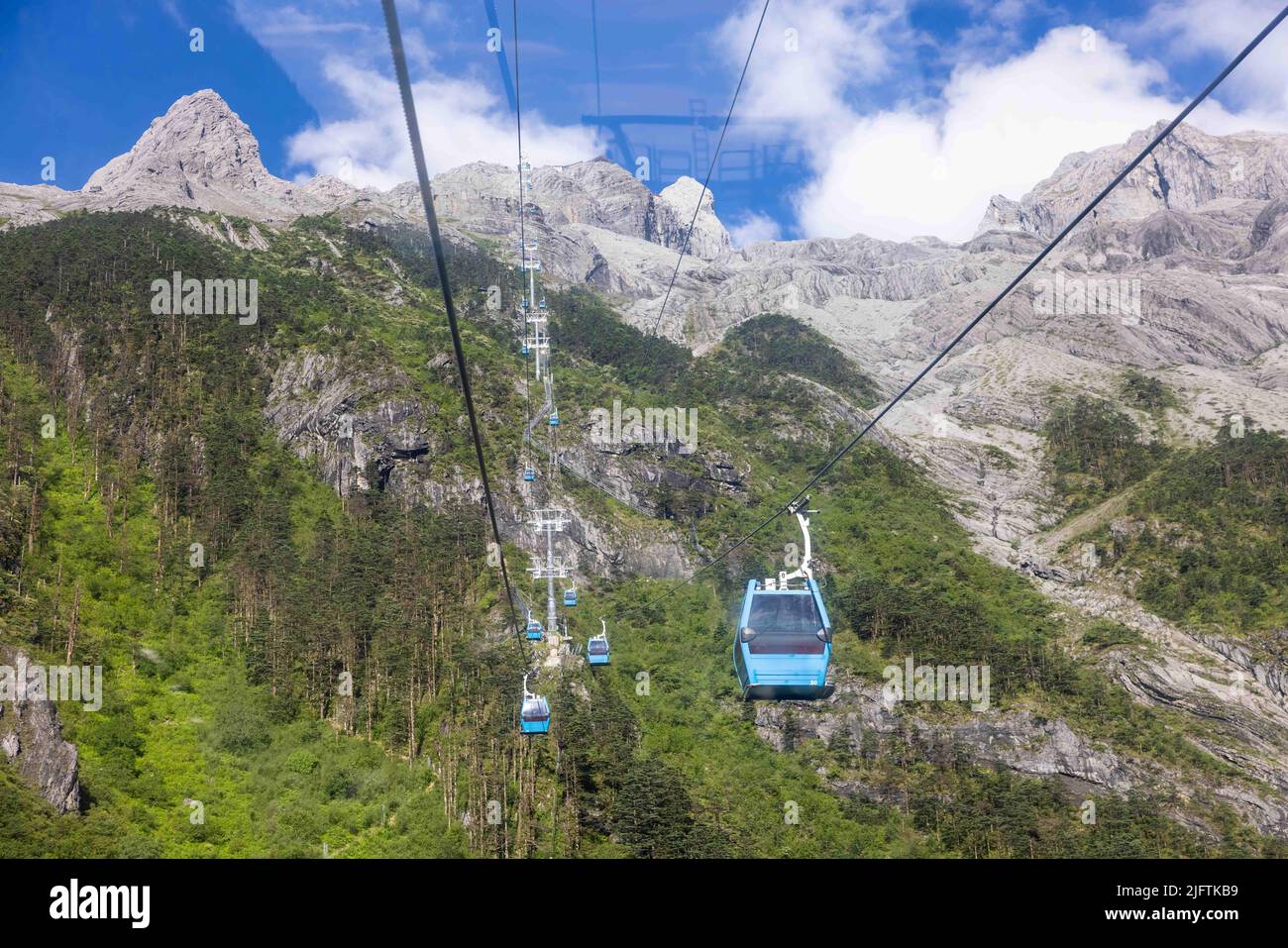 LIJIANG, CHINA JULY 5, 2022 Tourists ride a cable car at yulong