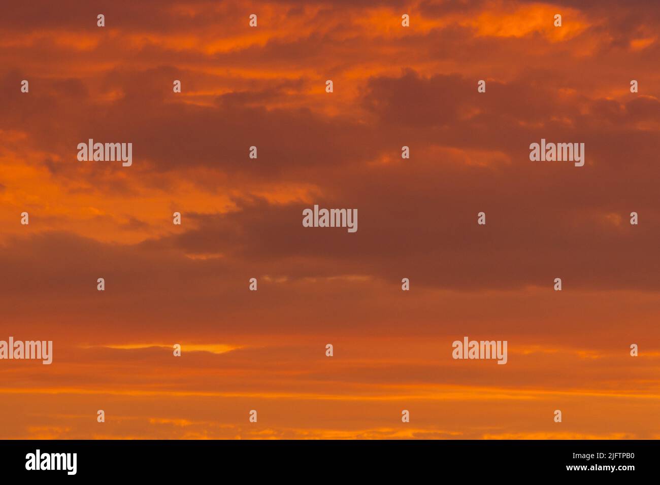 Colorful clouds of various shades on sunrise sky. Abstract and dramatic clouds background. Stock Photo