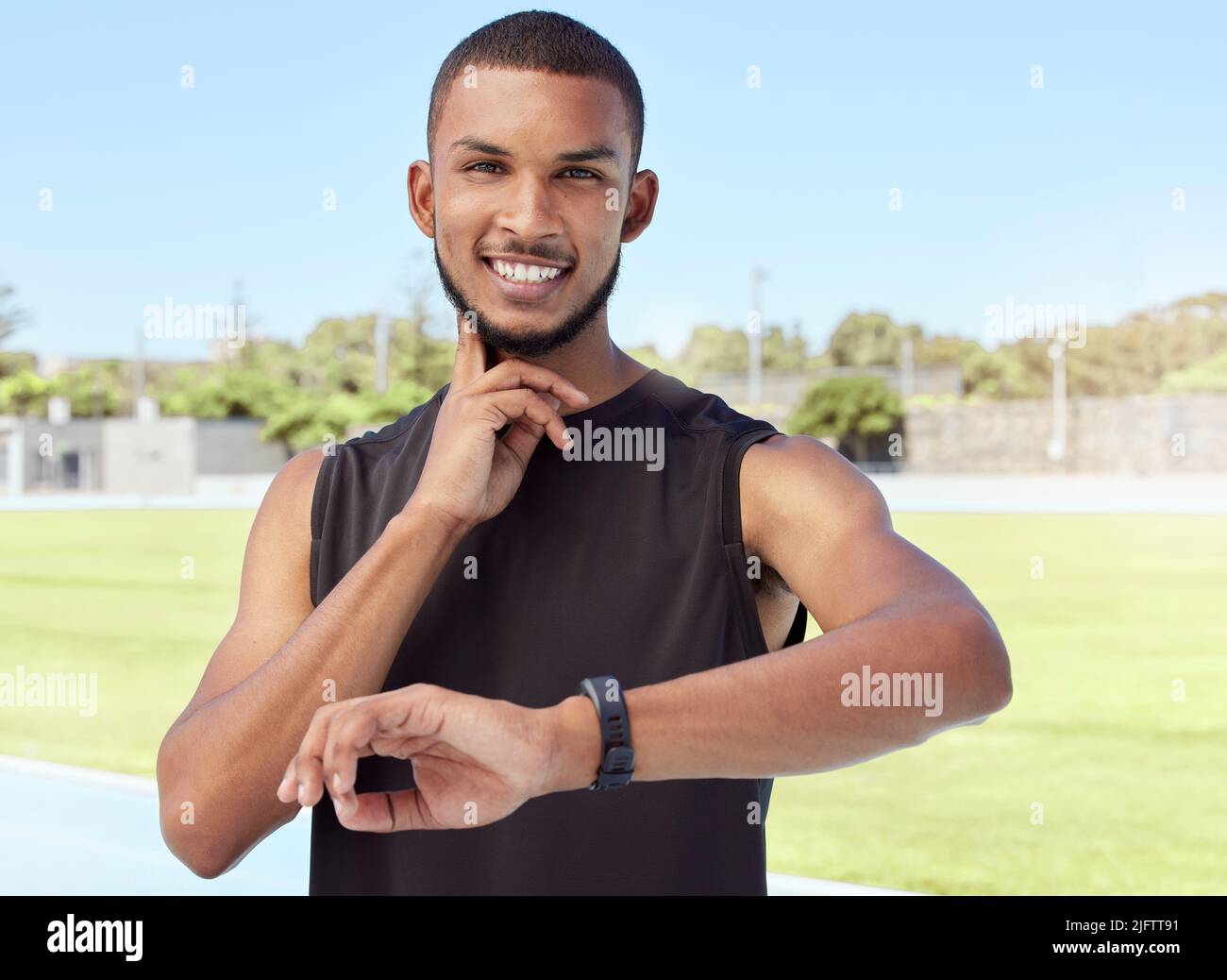 Young athlete using a fitness tracker to monitor progress, heart rate and calories burned during a workout. Portrait of a sportsman checking his pulse Stock Photo