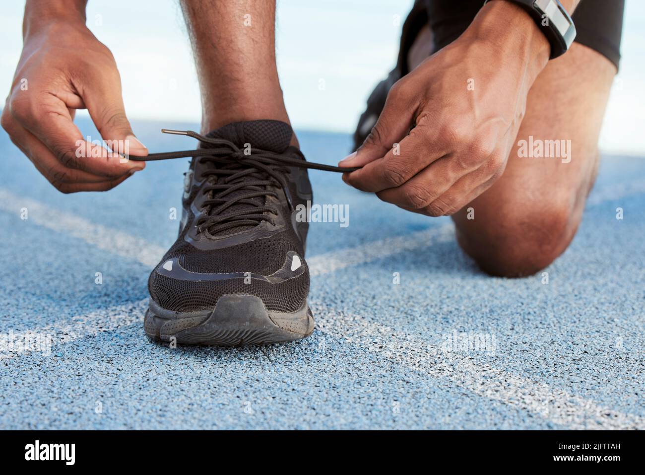 Preparing for cardio training and endurance. Athlete tying shoelaces ...