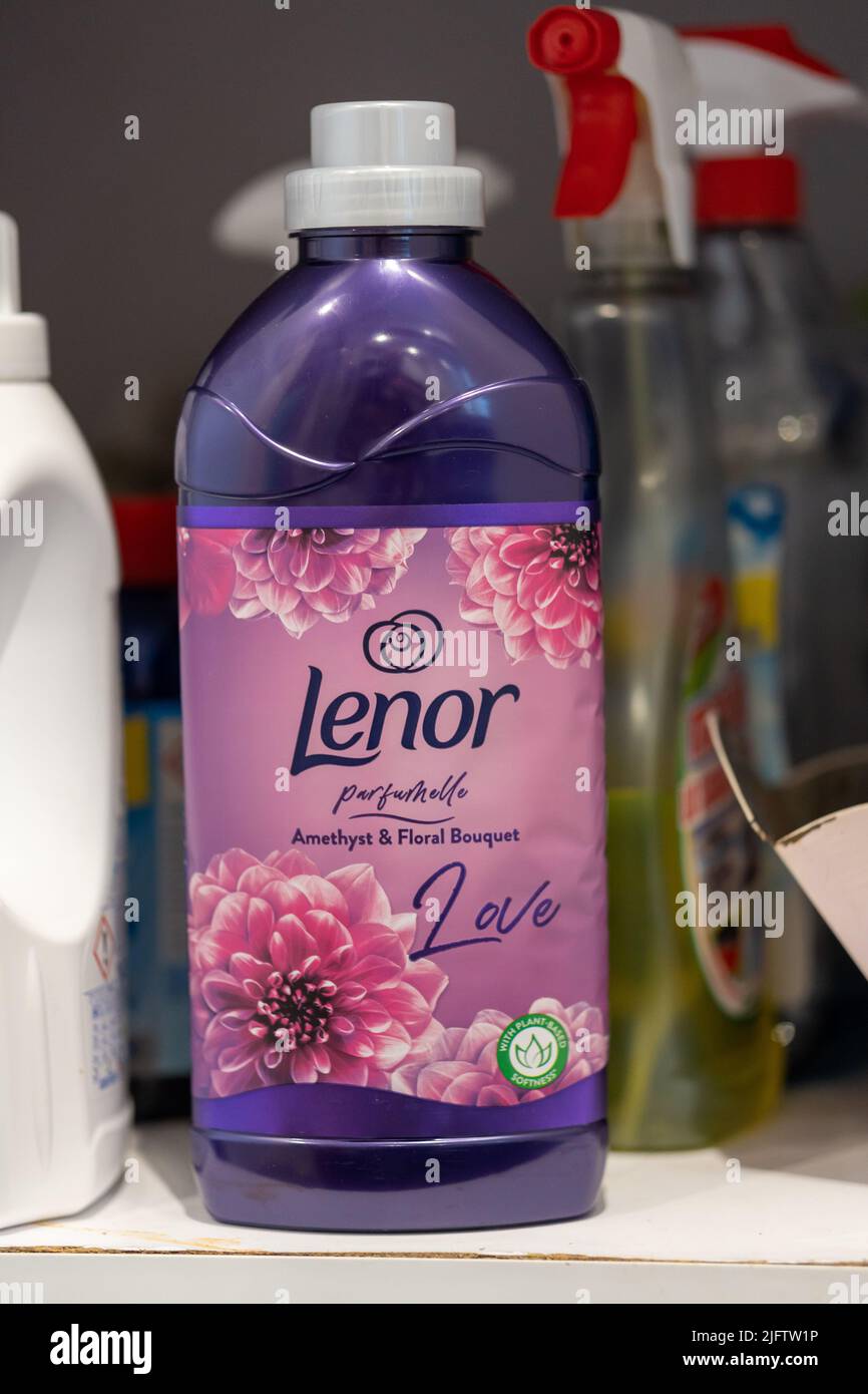 A vertical closeup of Lenor brand laundry detergent in a plastic bottle
