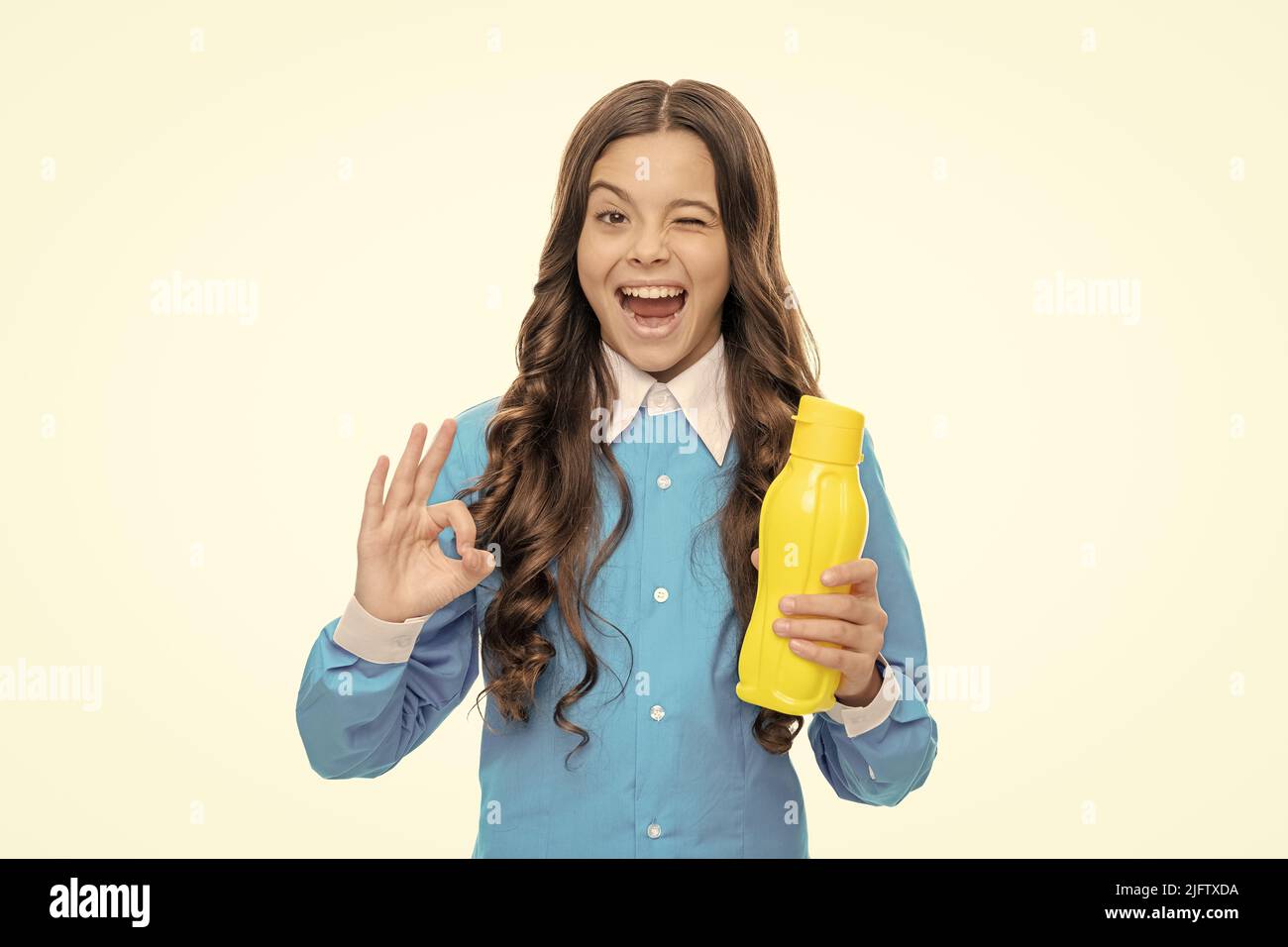 Drink it up. Playful child show OK sign holding plastic bottle. Beverage product. Beverage packaging Stock Photo