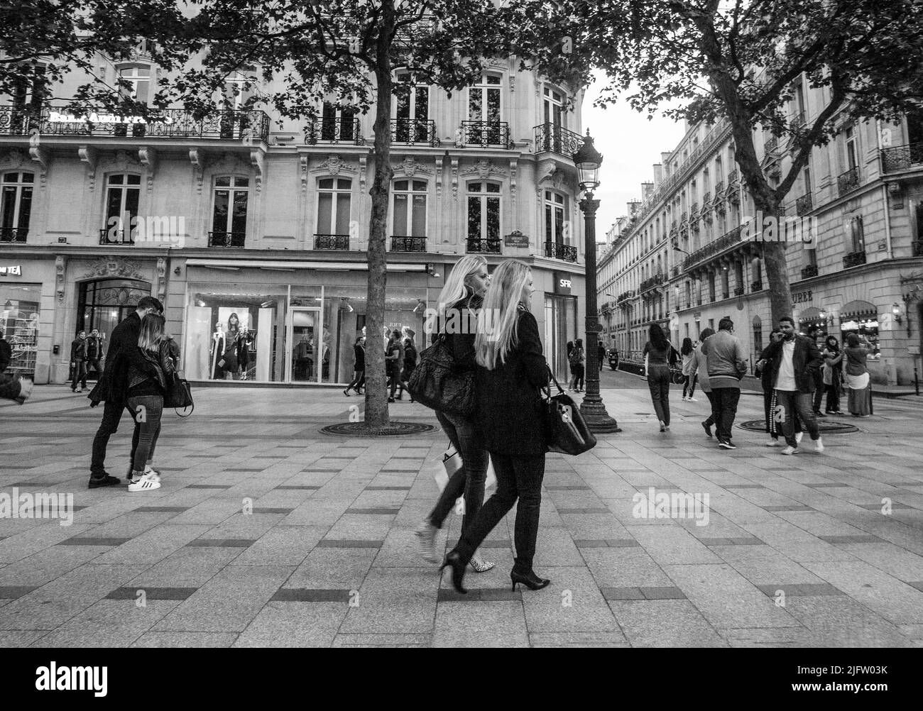 05-14-2016  Paris.   Blondies  blondes in heels and smiling  on Champs Elysees of Paris  - stylized in monochrome. Stock Photo