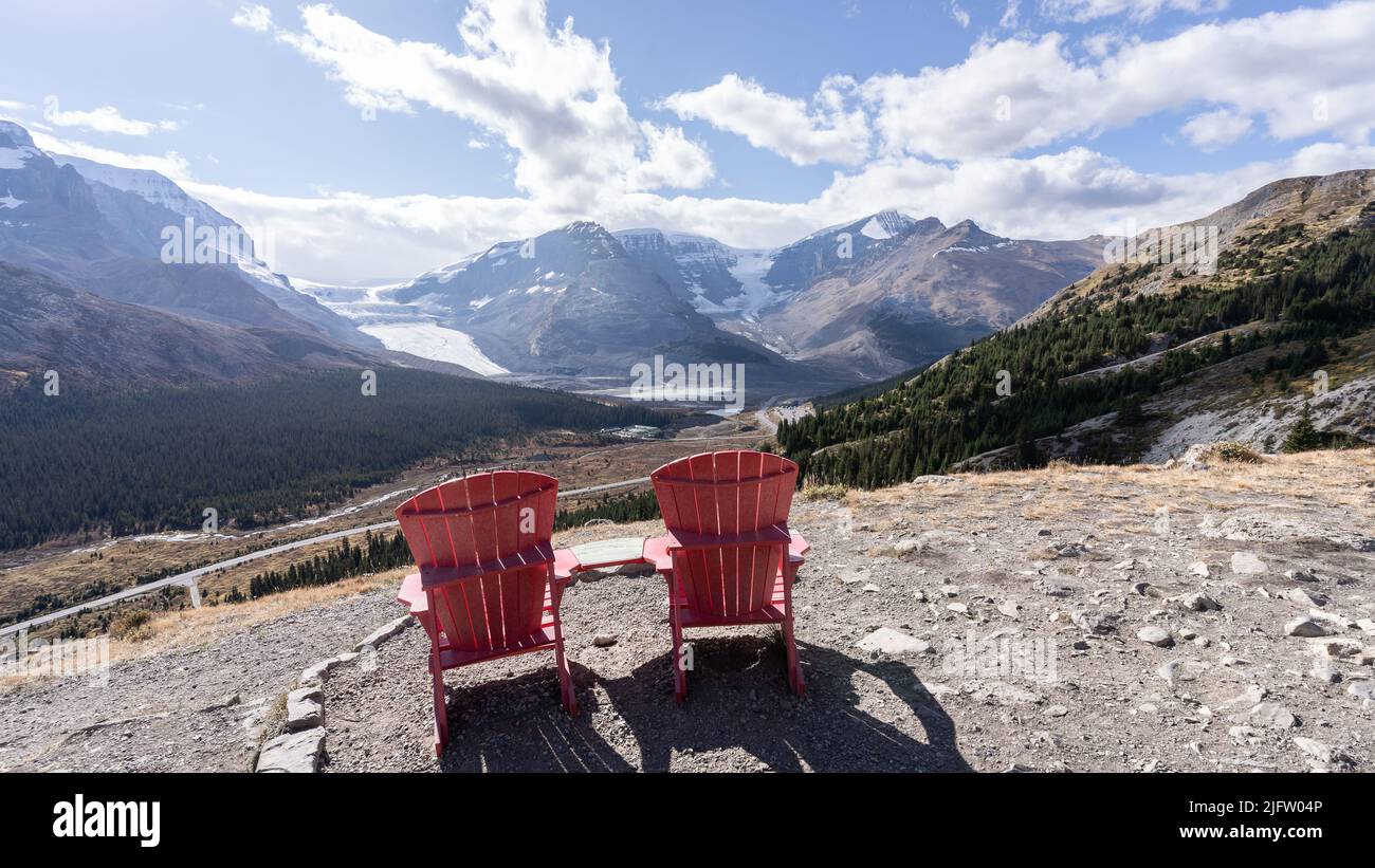 Two red chairs overlooking beautiful view on alpine valley with mountains and glaciers,Jasper,Canada Stock Photo