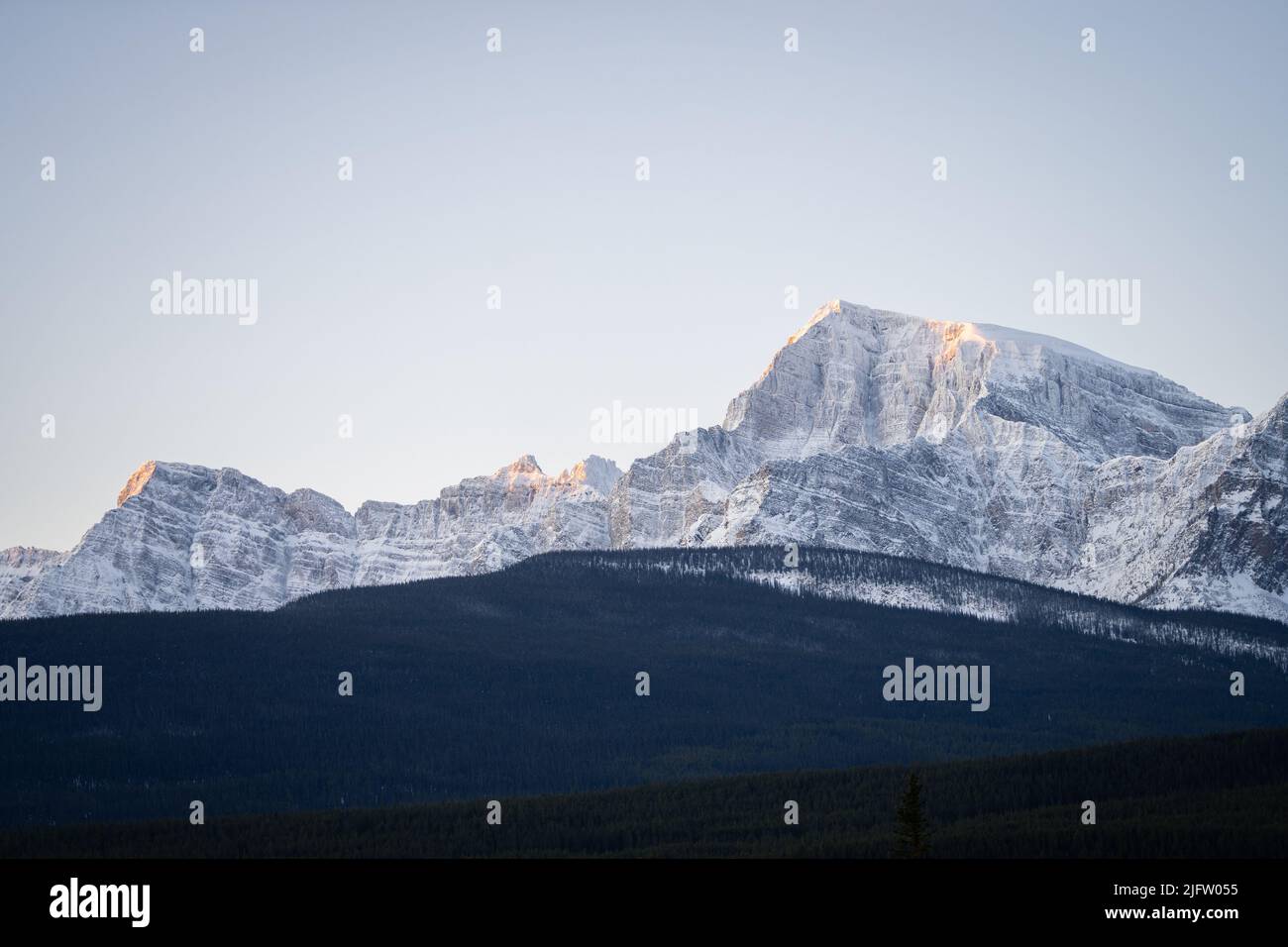 Mountain range catching first sun rays on a cold winter morning, Banff N. Park, Canada Stock Photo
