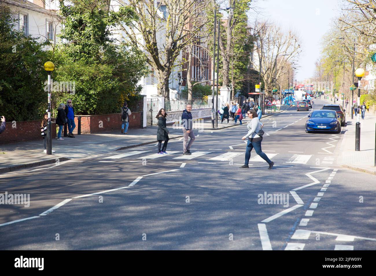People walk on the zebra crossing near Abbey Road Studios in London
