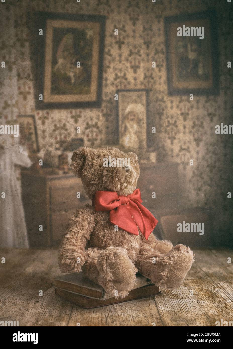 An old, worn child's teddy bear sitting on top of a table in a vintage interior Stock Photo