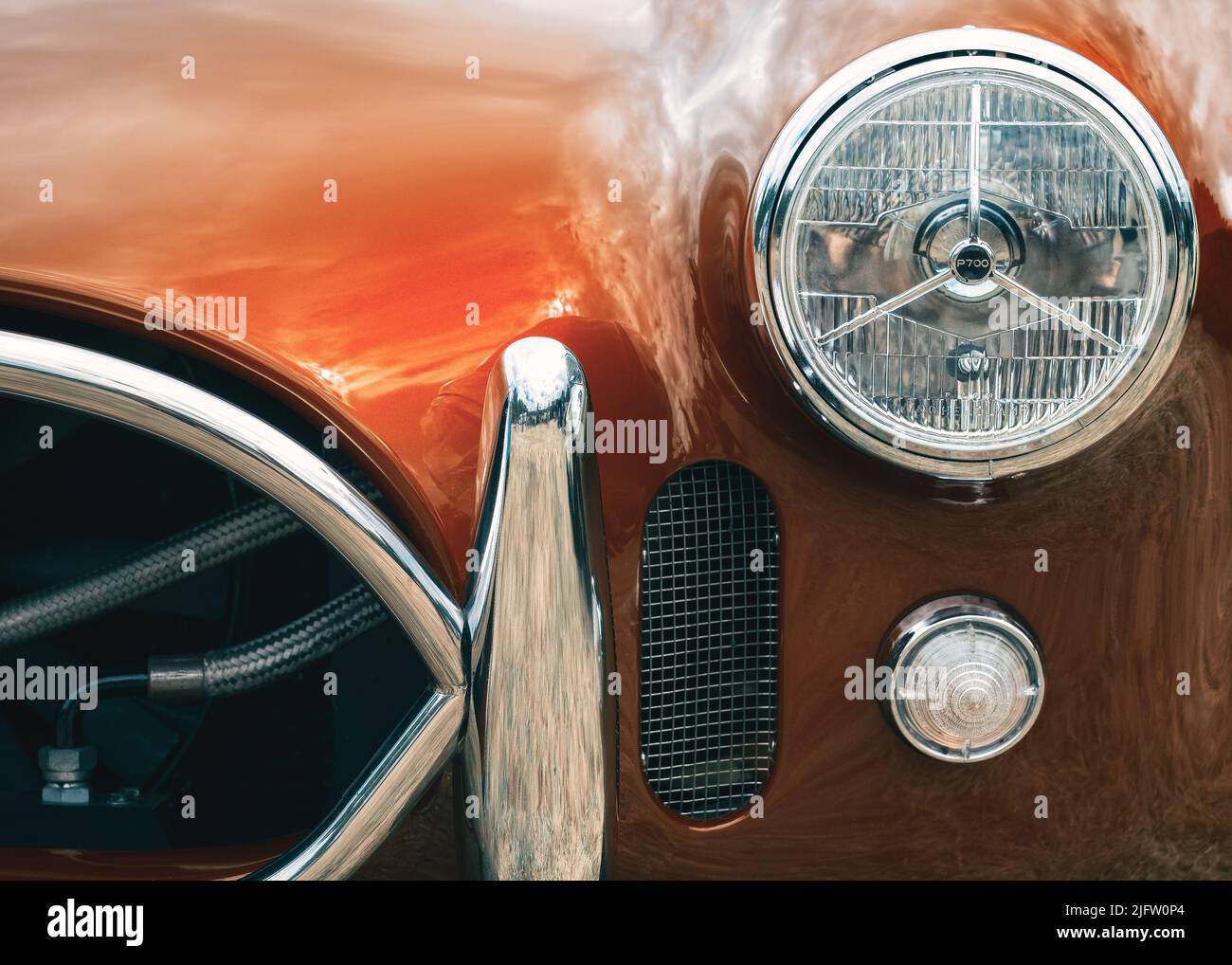 The front headlights and grill section of a red AC Cobra classic sports car Stock Photo