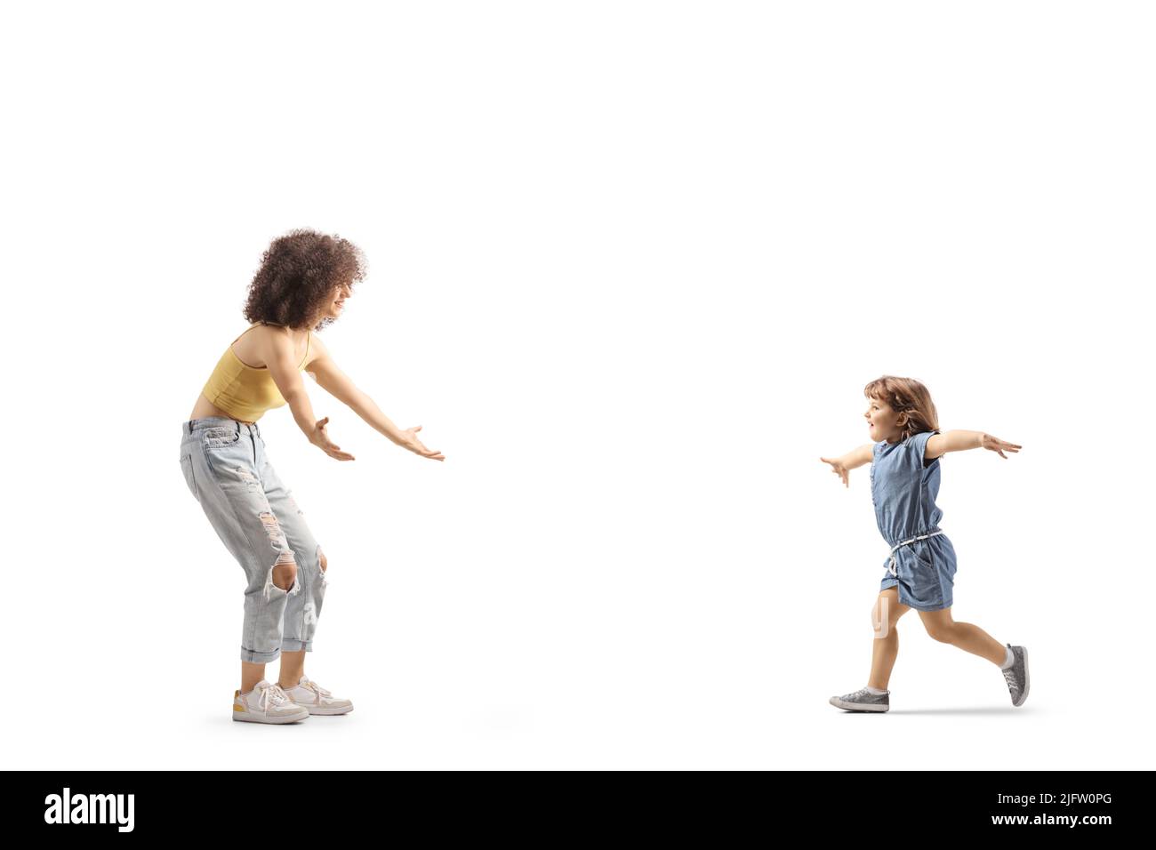Full length profile shot of a little girl running towards a young female with curly afro hairstyle isolated on white background Stock Photo