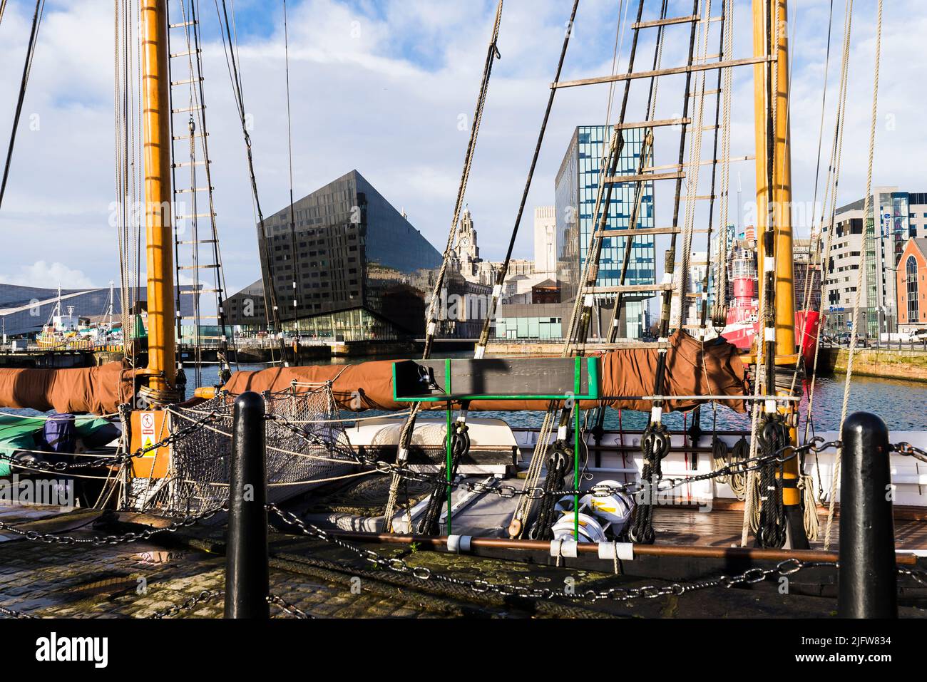 A classic ship set against the Liverpool cityscape at the Liverpool Docks. Liverpool, Merseyside, Lancashire, England, United Kingdom Stock Photo