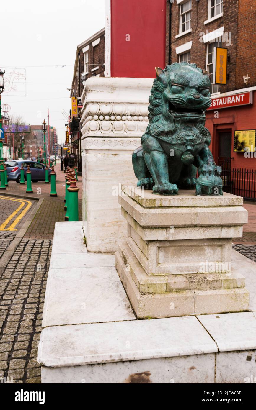 A lion statue next to Chinatown Gate, Nelson Street. Chinatown is an area of Liverpool that is an ethnic enclave home to the oldest Chinese community Stock Photo