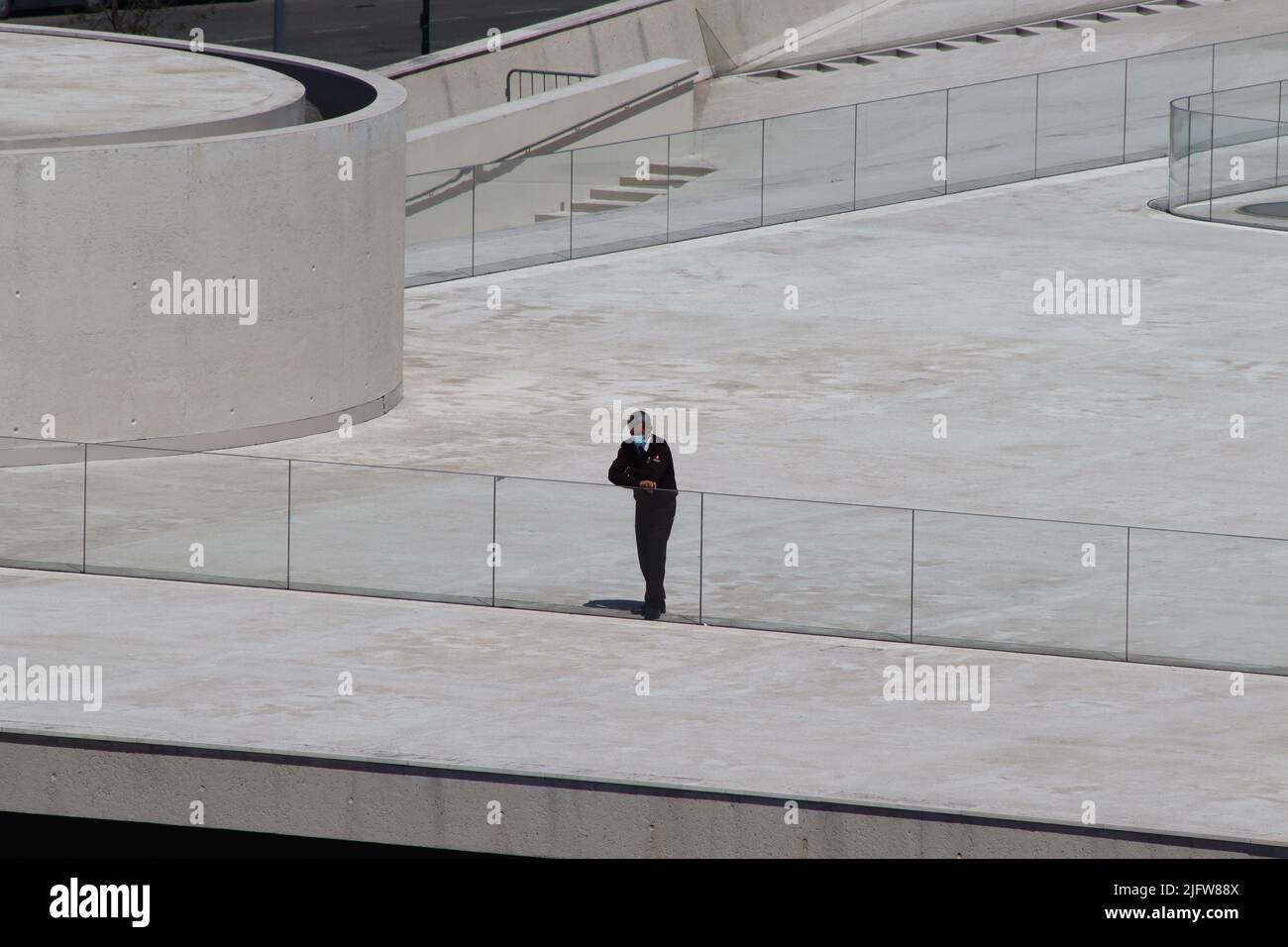 A lone security officer takes a break on the rooftop of Lisbon’s Santa Apolonia cruise terminal Stock Photo