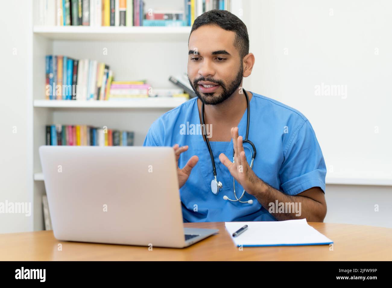 Video call of handsome latin american male nurse at computer at hospital Stock Photo