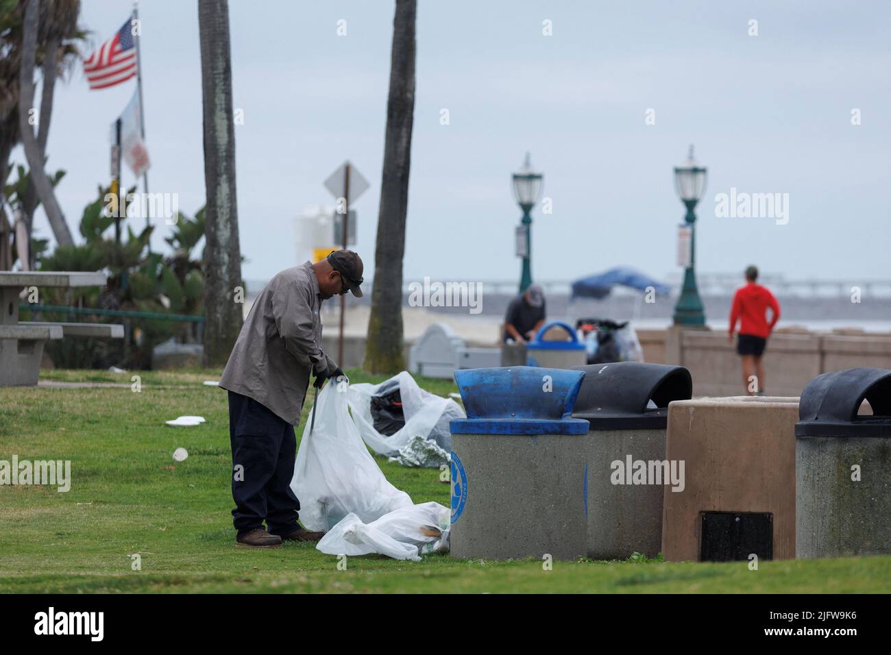 Cleanup begins following the Fourth of July holiday as a city worker picks up trash left behind at Pacific Beach in San Diego, California, U.S. July 5, 2022. REUTERS/Mike Blake Stock Photo