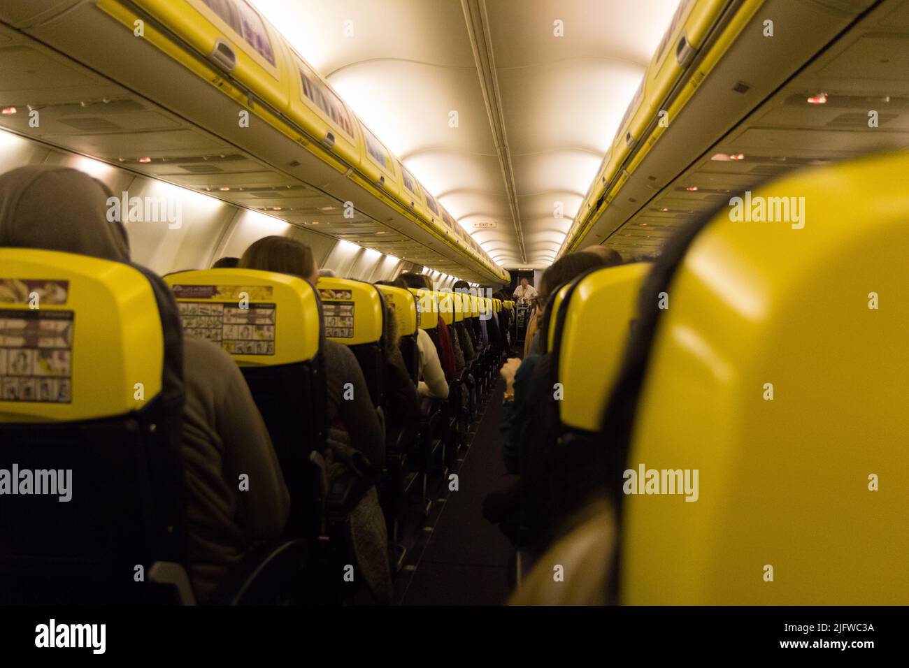 The aisle and the interior of a boarded plane. The aircraft is a Ryanair's Boeing 737-800. Stock Photo