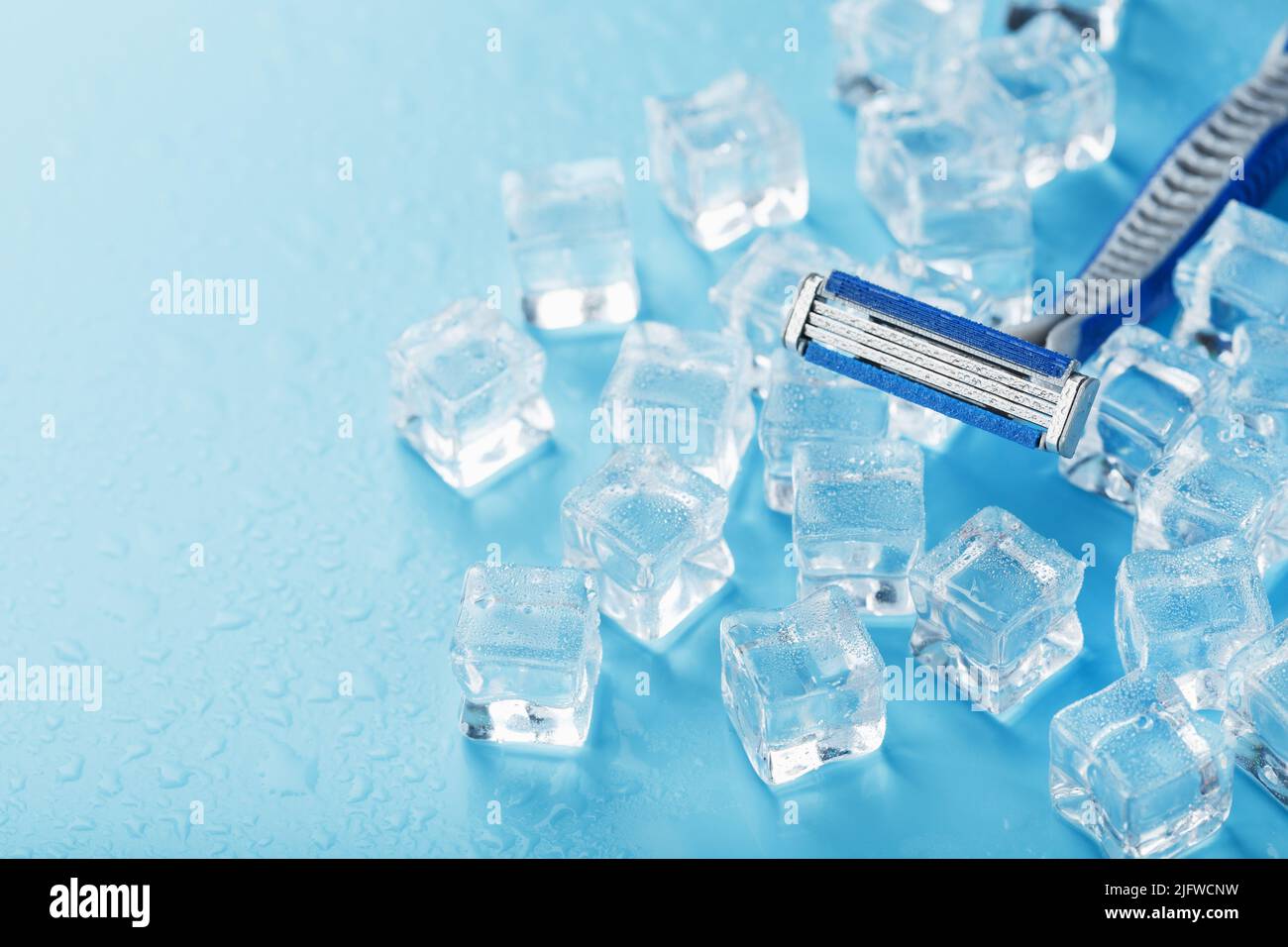 Shaving machine on a blue background with ice cubes. The concept of cleanliness and frosty freshness Stock Photo