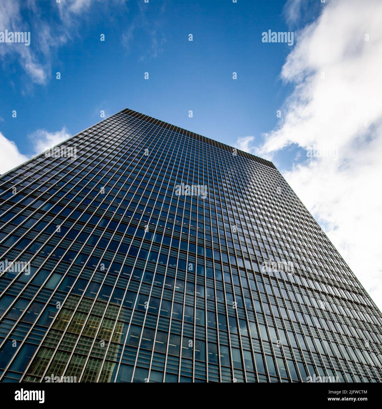 Business Architecture. Low angle view of a generic skyscraper in London's business district, Docklands, set against sky and clouds copy space. Stock Photo