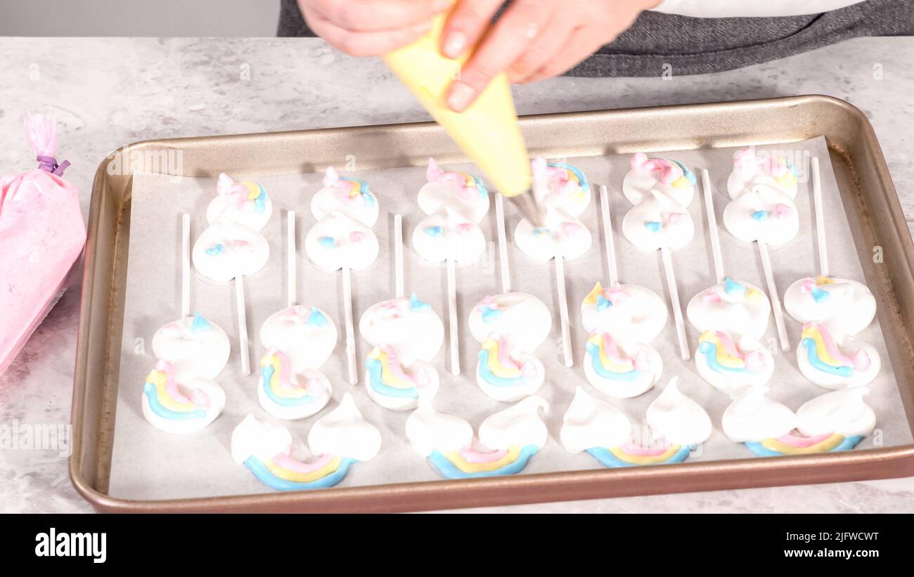 Step by step. Piping meringue mix into unicornshaped pops on a baking