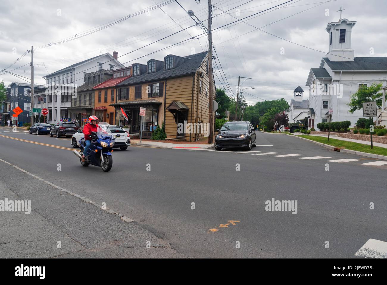 Traveler motorcyclist rides along the main street of French Town