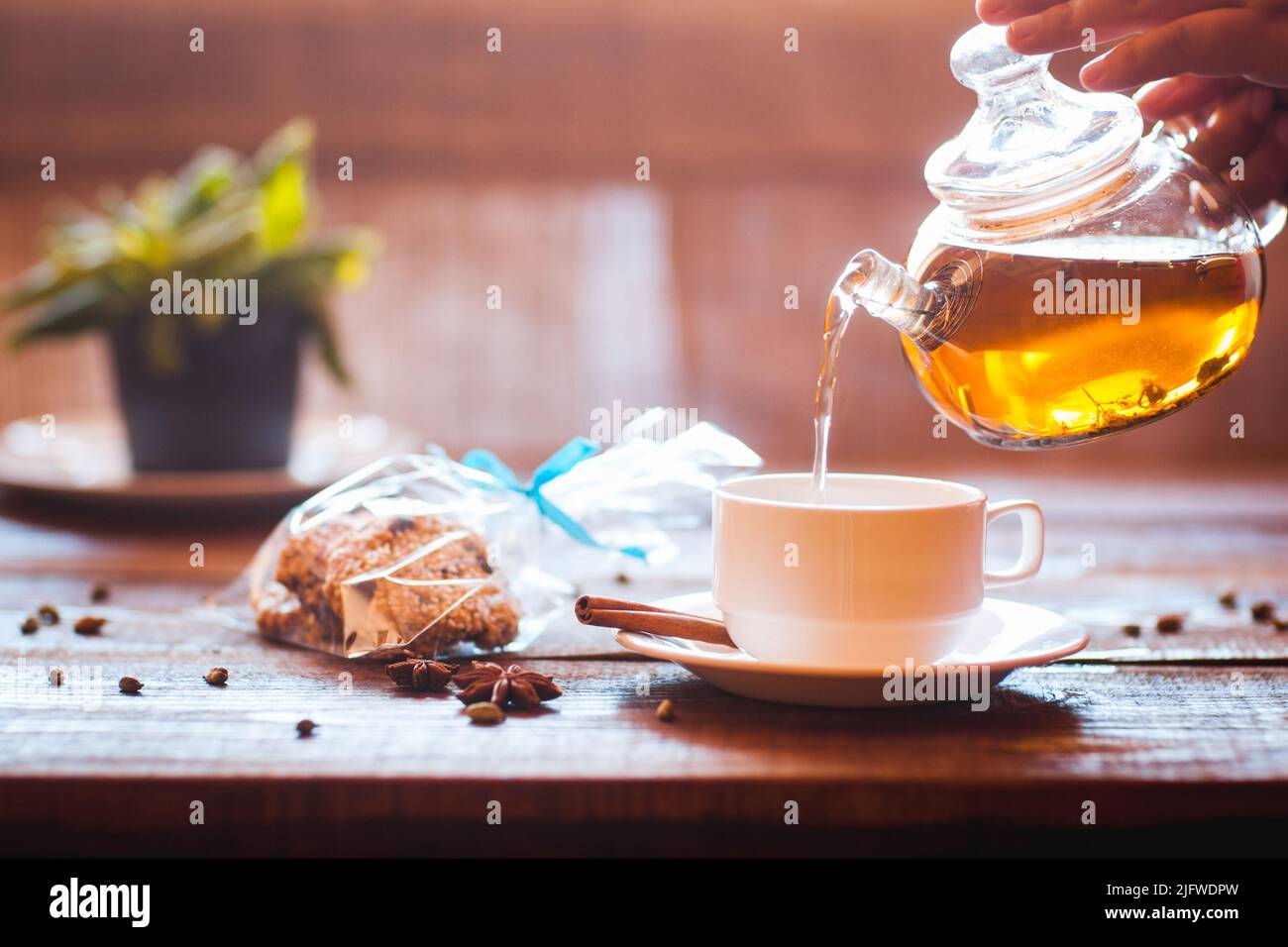Green tea flows from a teapot in a cup Stock Photo Alamy