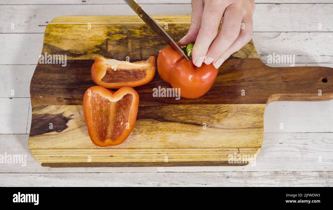 Mincing organic red bell peppers on a wood cutting board Stock Photo ...