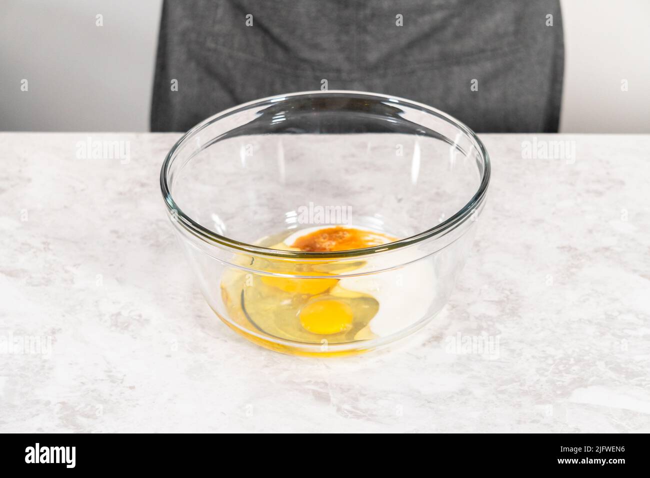 Mixing ingredients in a glass mixing bowl with a blending whisk to bake