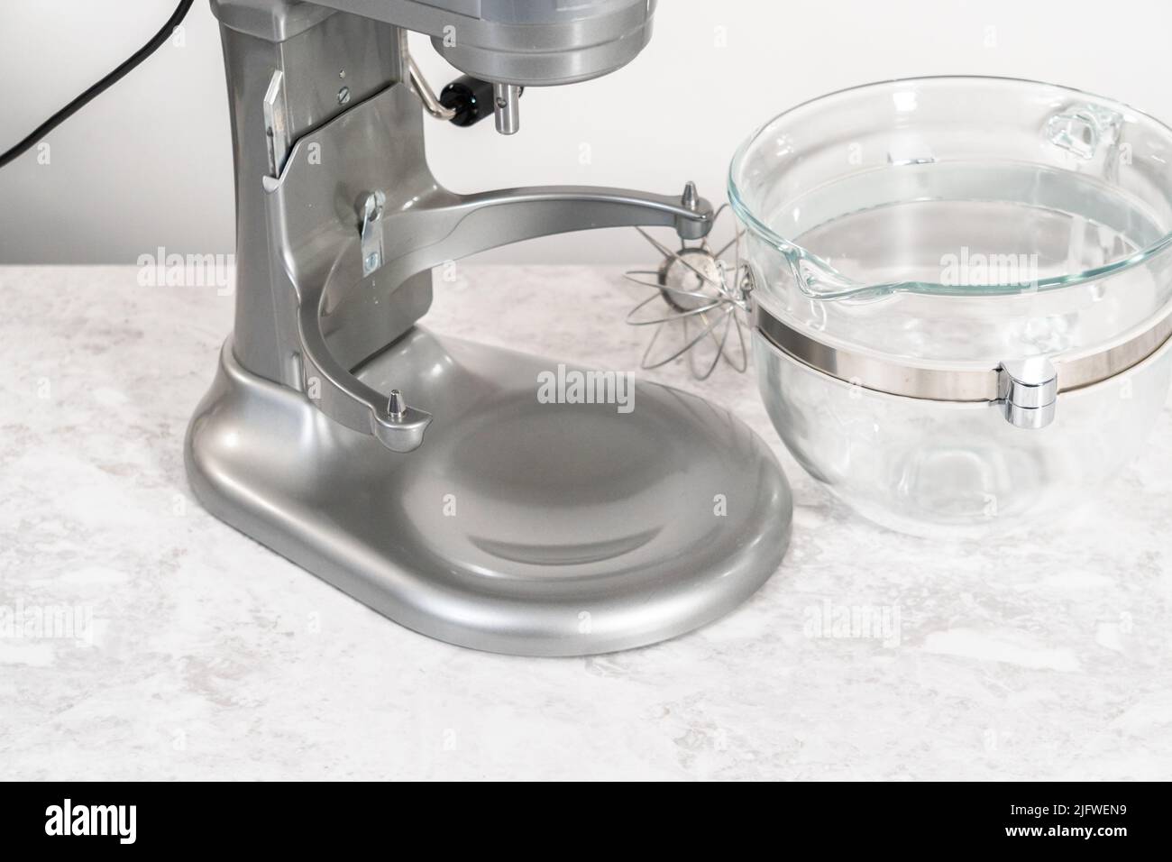 Whipping strawberry buttercream frosting in a standalone electric