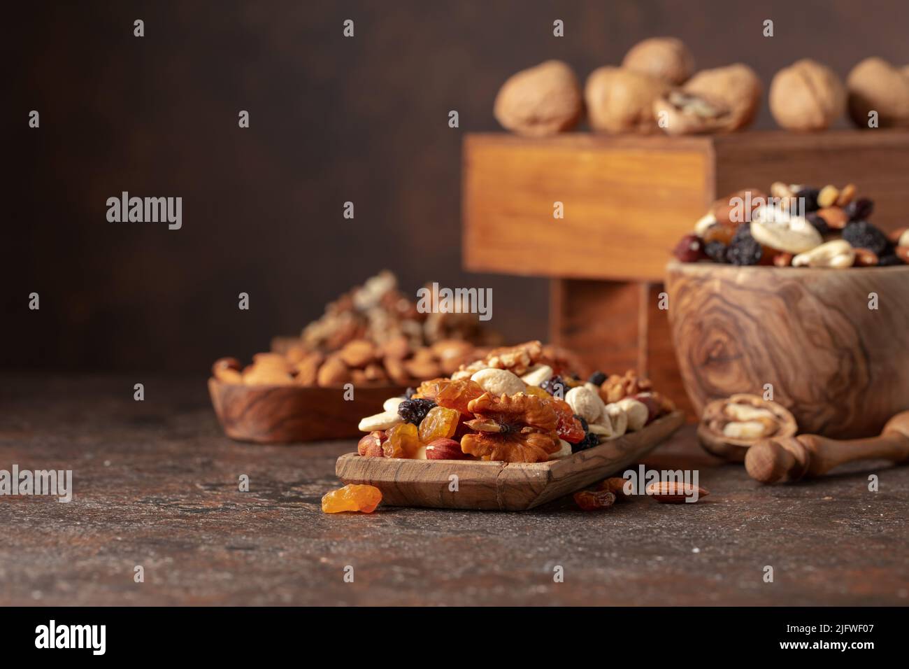 Mix of nuts and raisins on a brown rustic background. Presented raisins