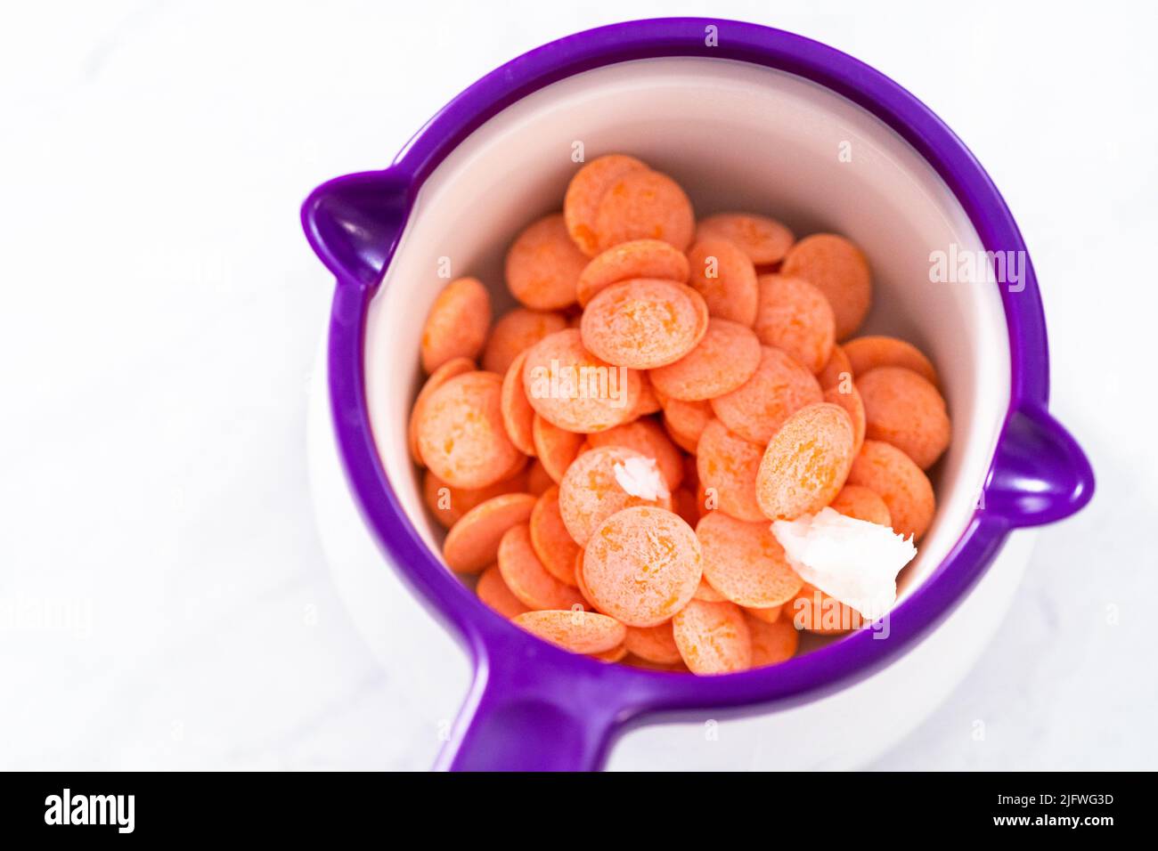 Melting chocolate chips in a candy melting pot to make a chocolatecovered pretzel twists Stock