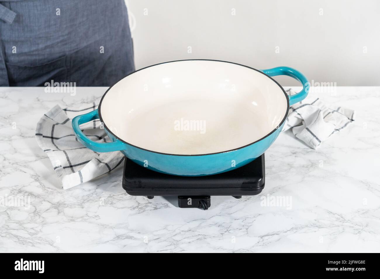 Frying marinated shrimp in a cast iron frying pan to prepare garlic