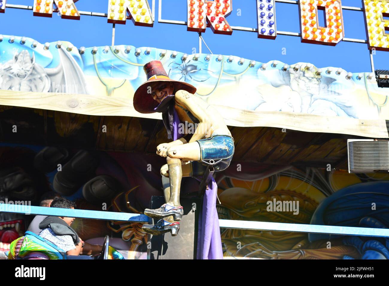 Terrifying figure hanging in front of a toy with the name ghost train or dark ride, train style toy to scare, Brazil , bottom-up view Stock Photo