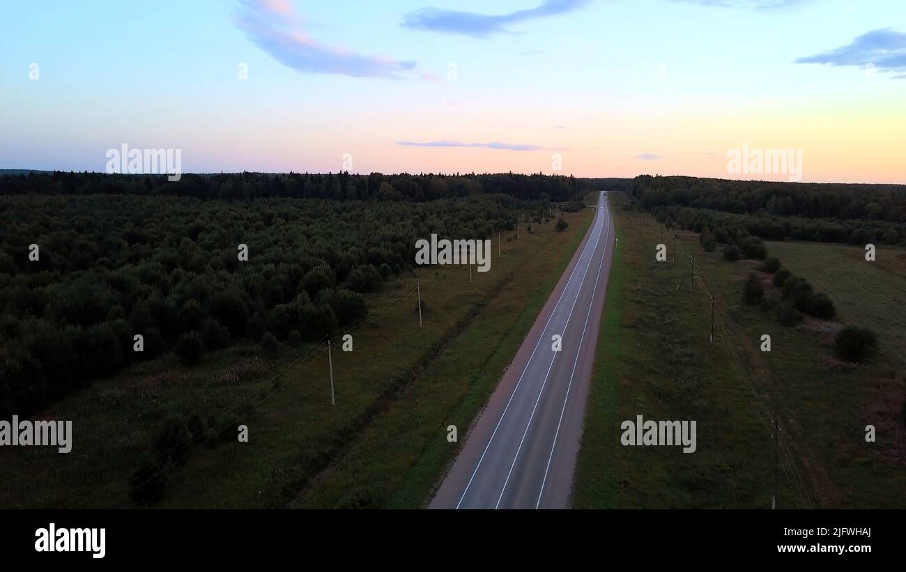 Green forest from a bird's-eye view.Clip. Beautiful long green trees in the landscape next to which you can see the road on which cars drive. High qua Stock Photo