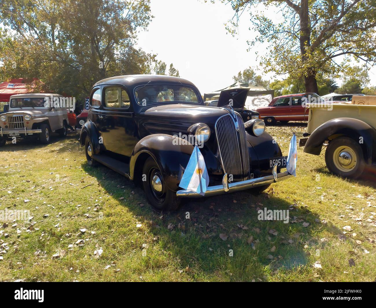 Old black Plymouth two door fastback sedan circa 1937 parked in the countryside. Nature grass and trees background. Front view. Classic car show Stock Photo